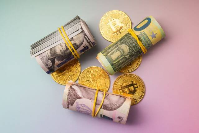 輪ゴムで縛られたお札の束3つとコイン4枚